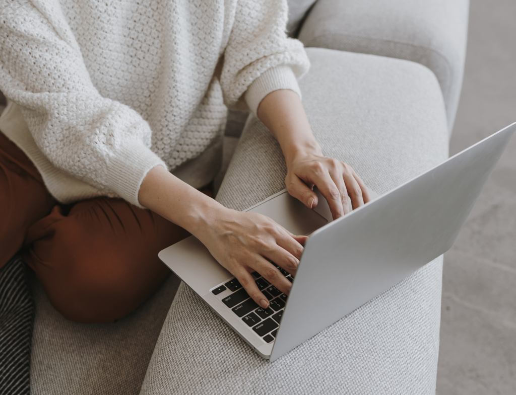 Woman working focused on a laptop at a sunlit desk during a calm Workroom60 virtual coworking session